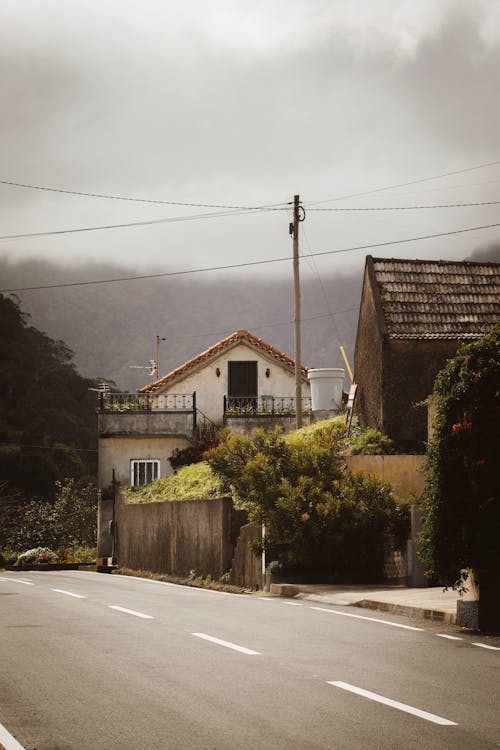 A street with a house on it and a mountain in the background
