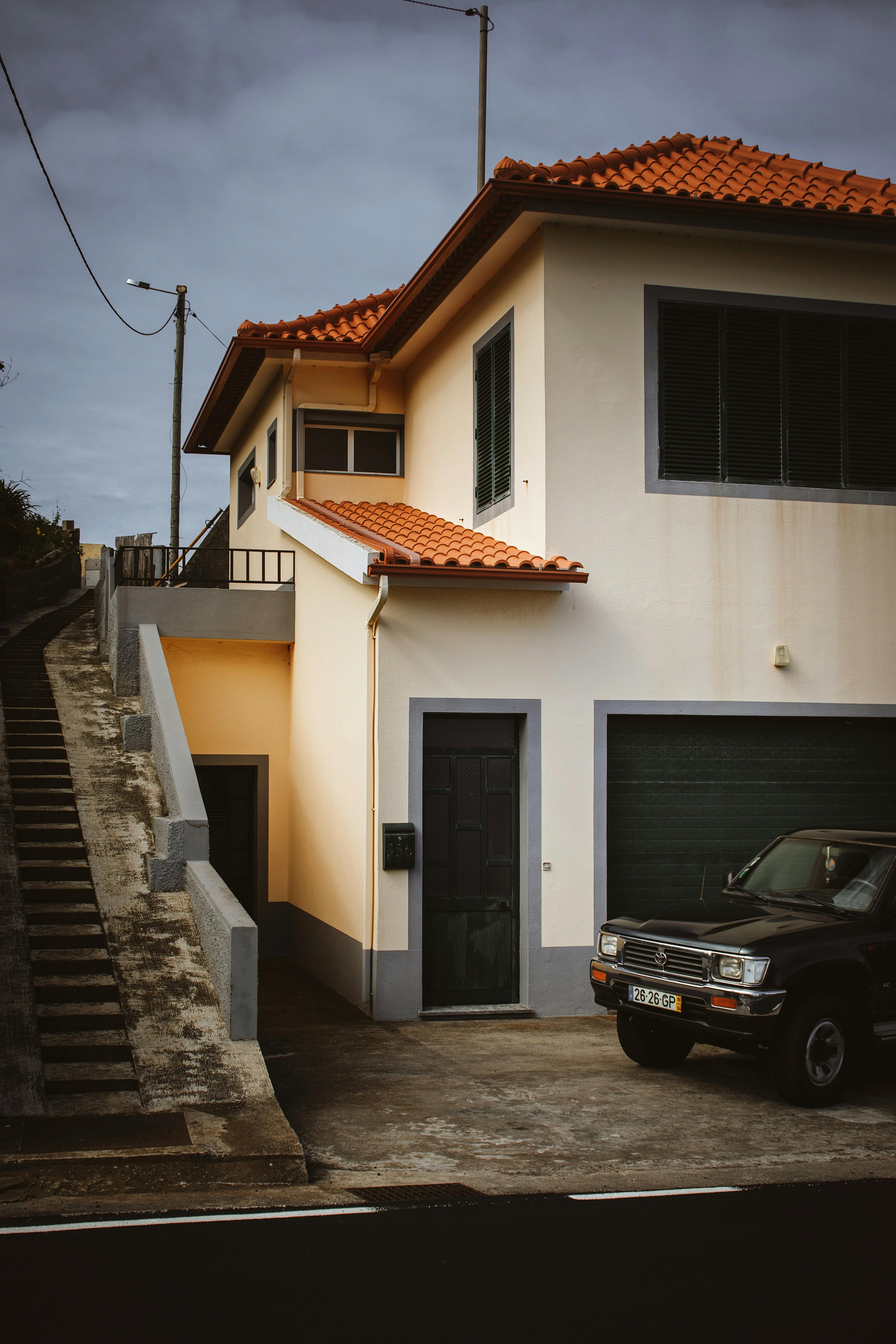 Free Stylish house with orange roof in Madeira, Portugal beside parked car. Stock Photo