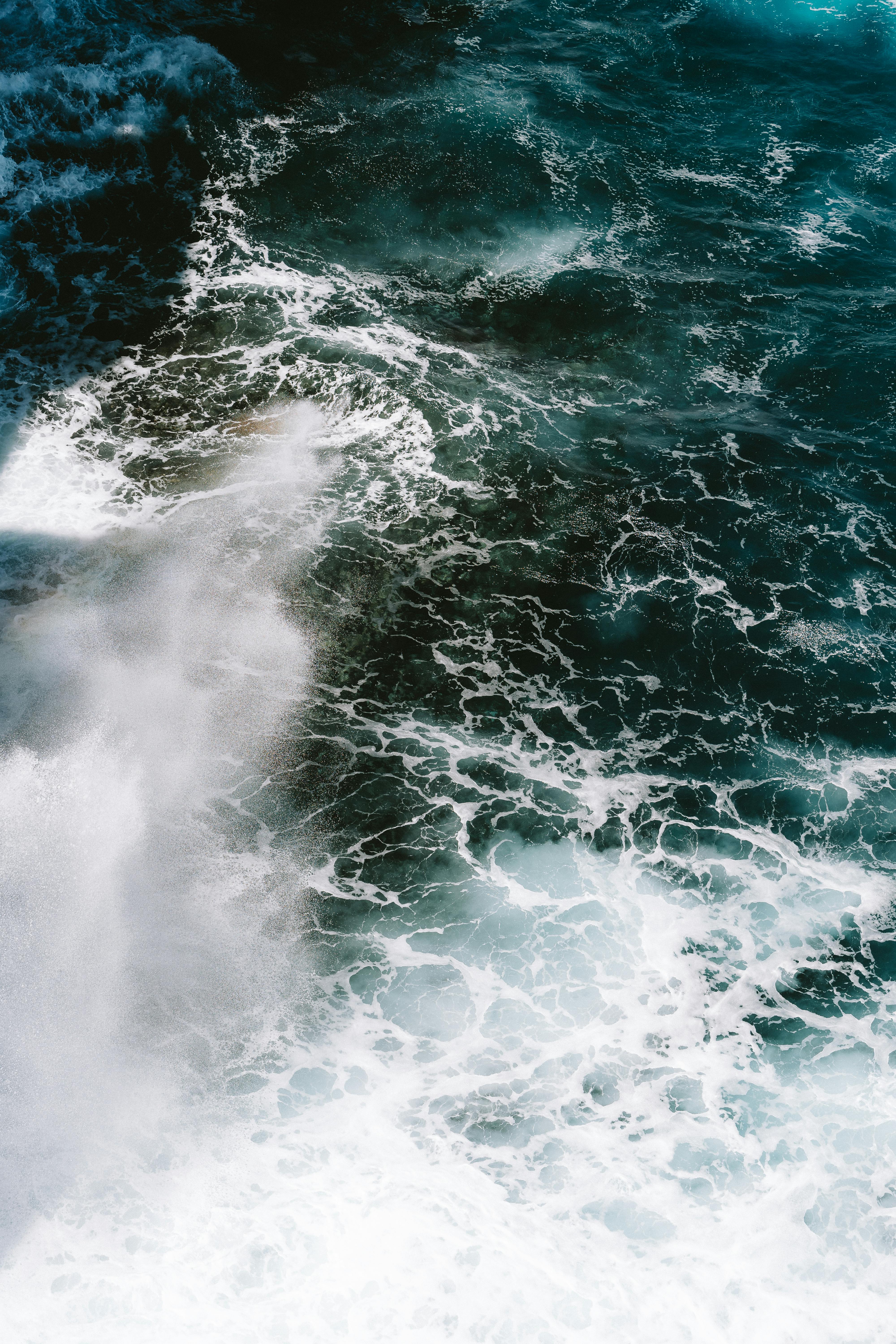 Captivating aerial view of crashing waves and ocean foam at Torndirrup National Park, Australia.