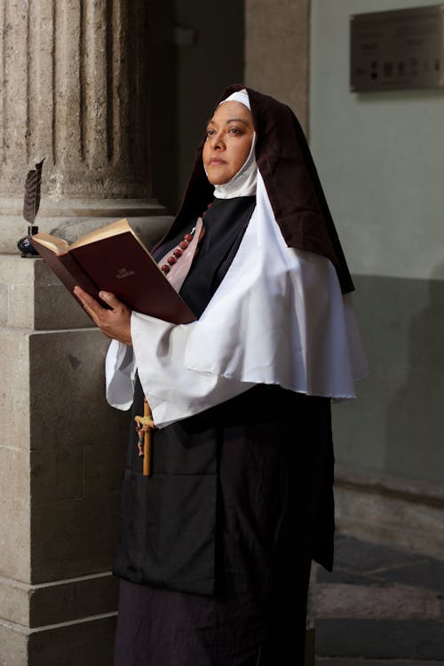 Nun in Gown Holding Bible in Hands