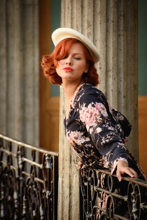 Elegant Woman in a Dress and Beret Standing by the Balustrade 