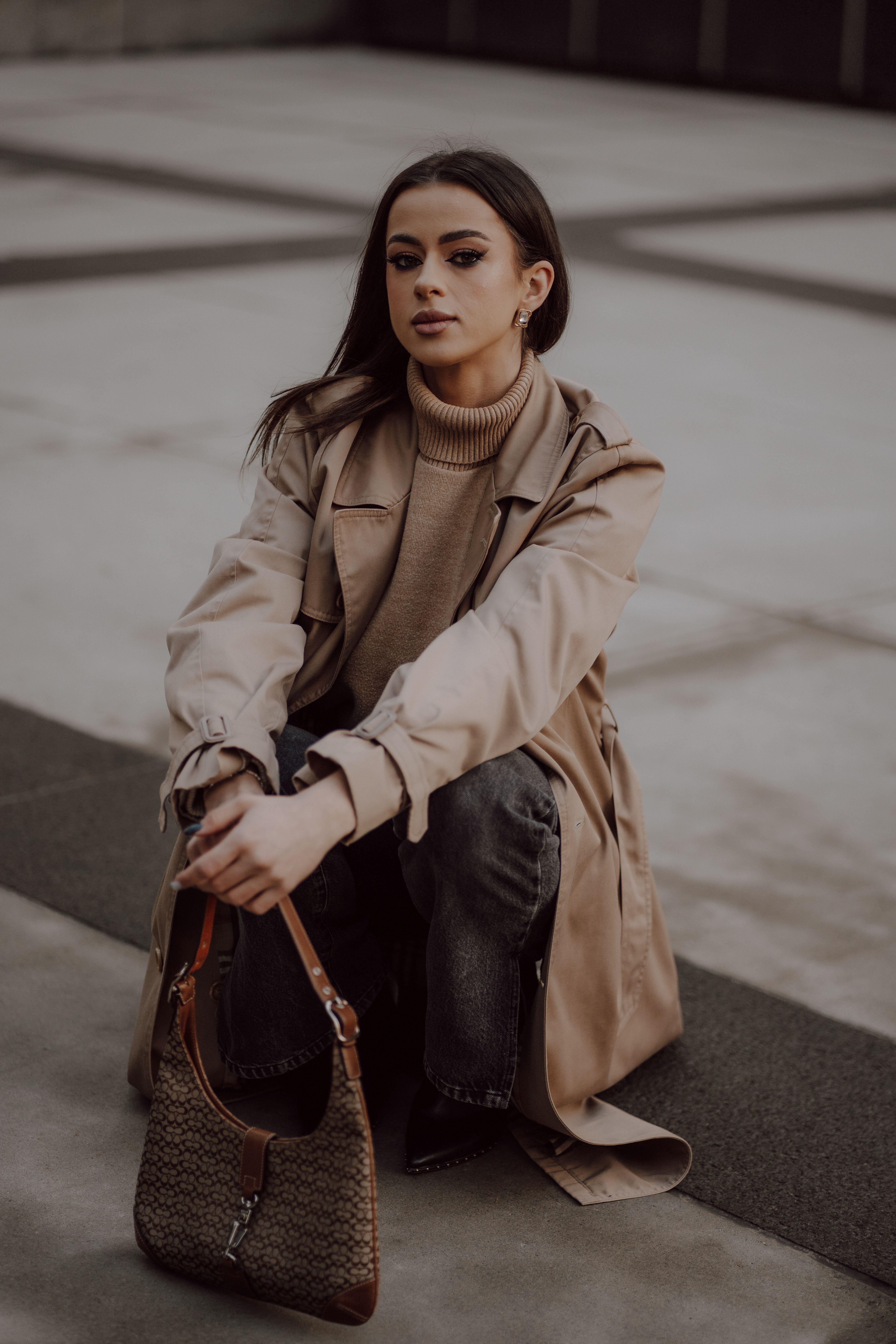 Brunette Woman Sitting in Trench and with Bag · Free Stock Photo