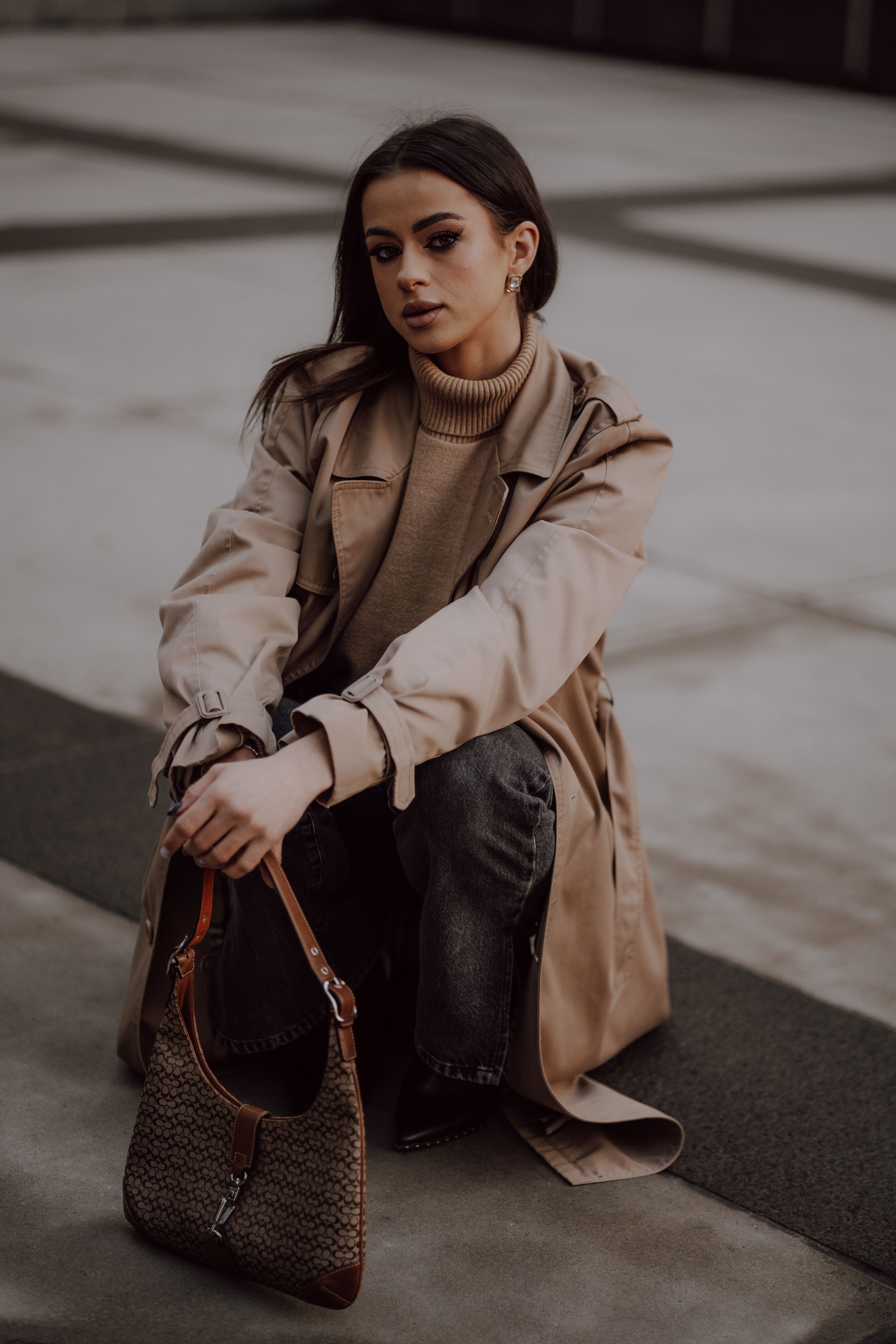 Crouching Woman in Trench Coat · Free Stock Photo