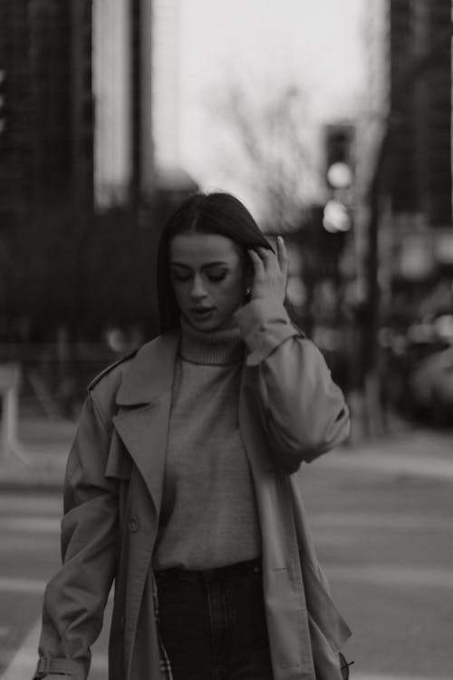 A woman in a trench coat is walking down the street