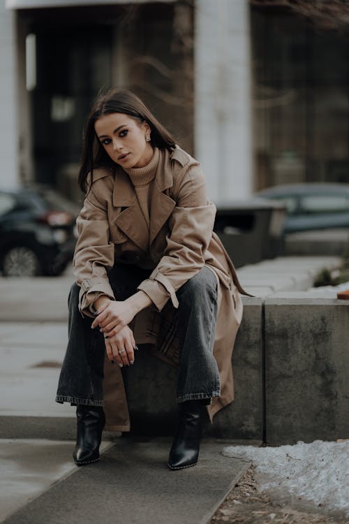 Woman Sitting in Trench on Wall