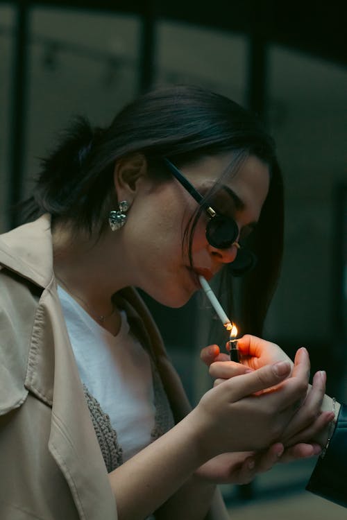 A woman smoking a cigarette in a dark room