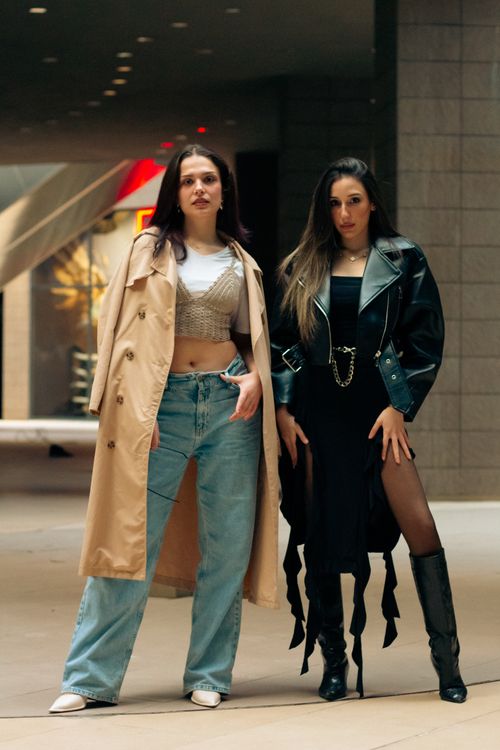 Free Two stylish women showcase urban fashion trends in a modern city environment. Stock Photo