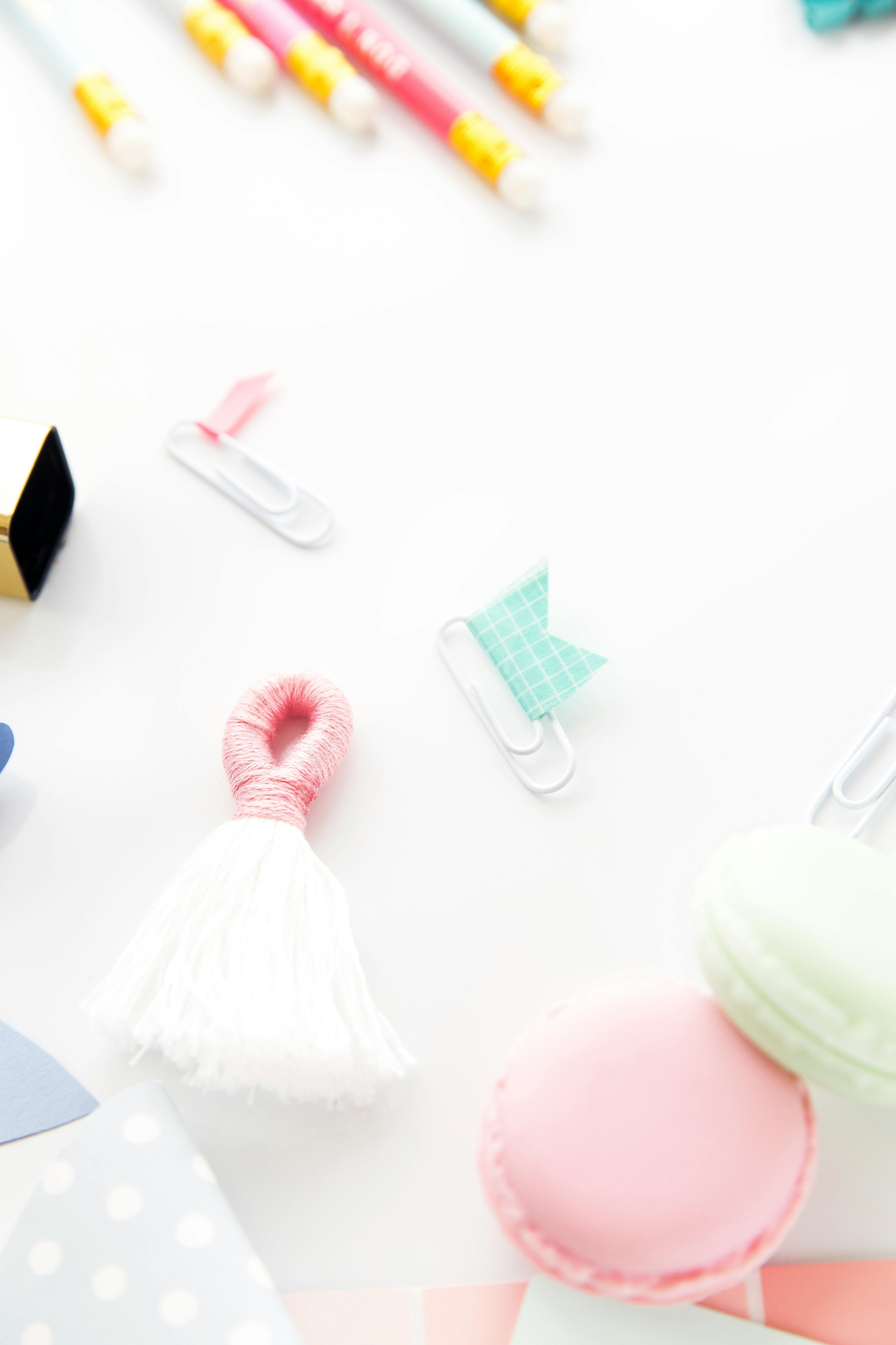 白色背景上排列着彩色办公用品，营造出一种有趣的创意工作空间氛围