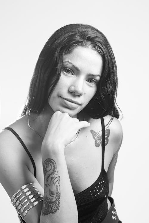A woman with tattoos posing for a black and white photo