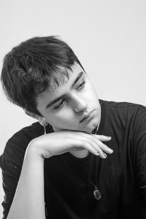 Free Black and white portrait of a teenager looking away, exuding a serene and introspective mood. Stock Photo