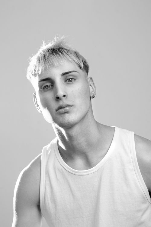 Free Black and white portrait of a young man wearing a white tank top against a gray background. Stock Photo