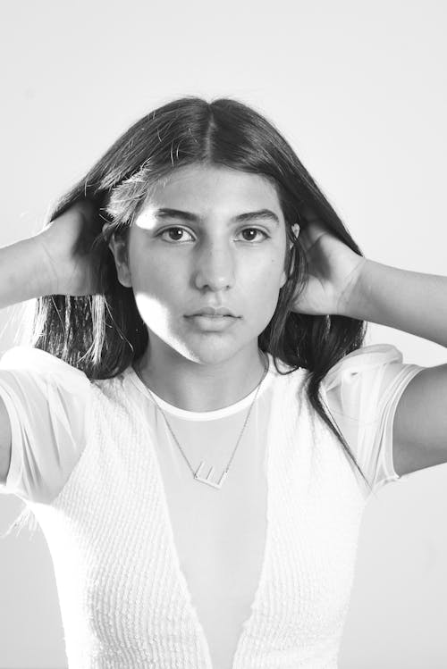 A woman with long hair is posing for a black and white photo