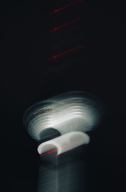 Artistic blurred shot of the iconic Fernsehturm tower in Berlin captured at night.