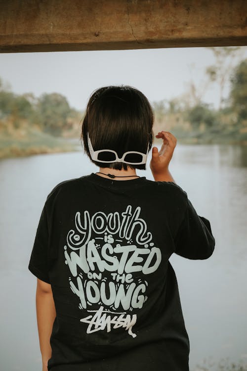 A young woman wearing a t - shirt that says youth is wasted