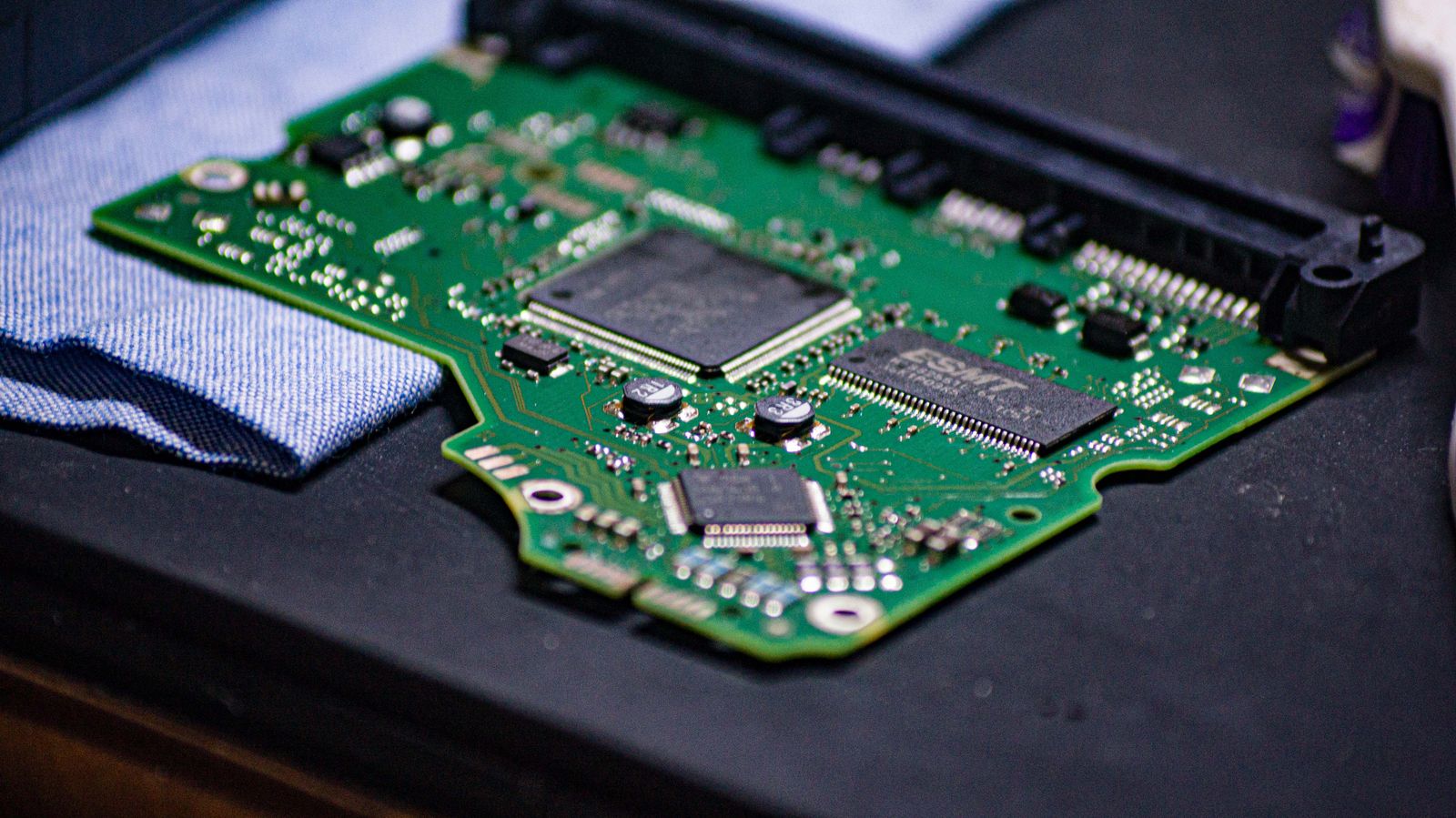Close-up of a green circuit board on a workbench