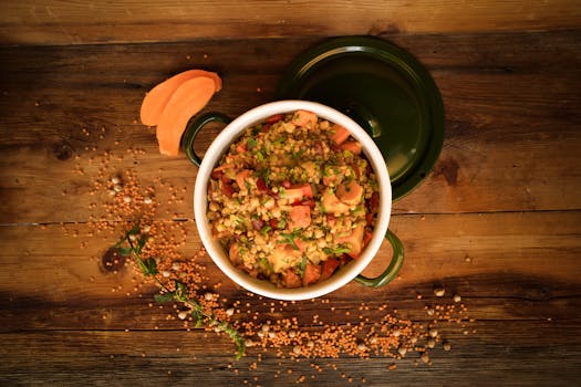 A top-down view of a colorful lentil and vegetable stew in a green pot, perfect for healthy meals.