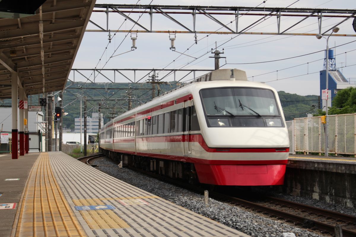 A red-and-white train arriving at a station platform in Kiryu City, Gunma