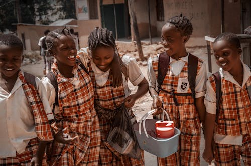 A group of children in school uniforms are smiling