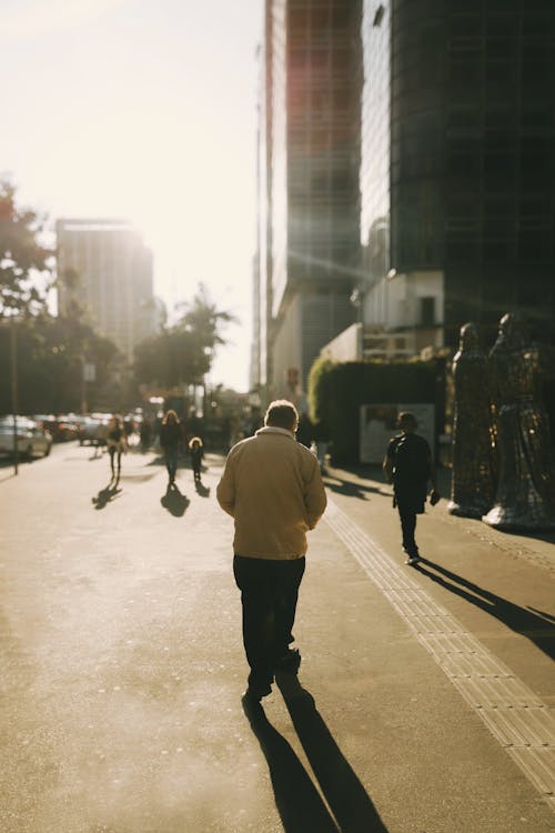 A man walking down a street in the sun