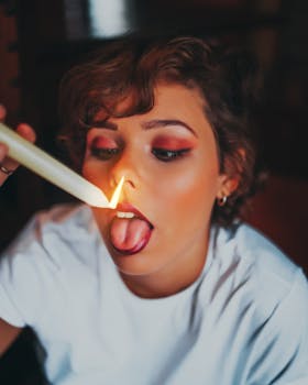 一张艺术照片中，女子与蜡烛火焰嬉戏，展现了创造力和表达力