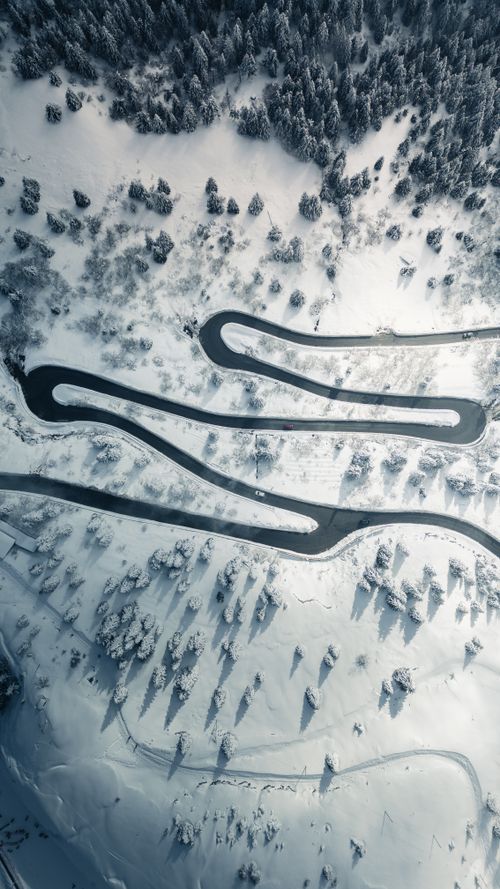Aerial View of Snowy Winding Road in Winter · Free Stock Photo