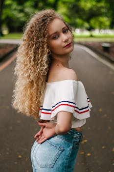 一位时尚女性在公园的肖像，展现了她的卷发和时髦衣着