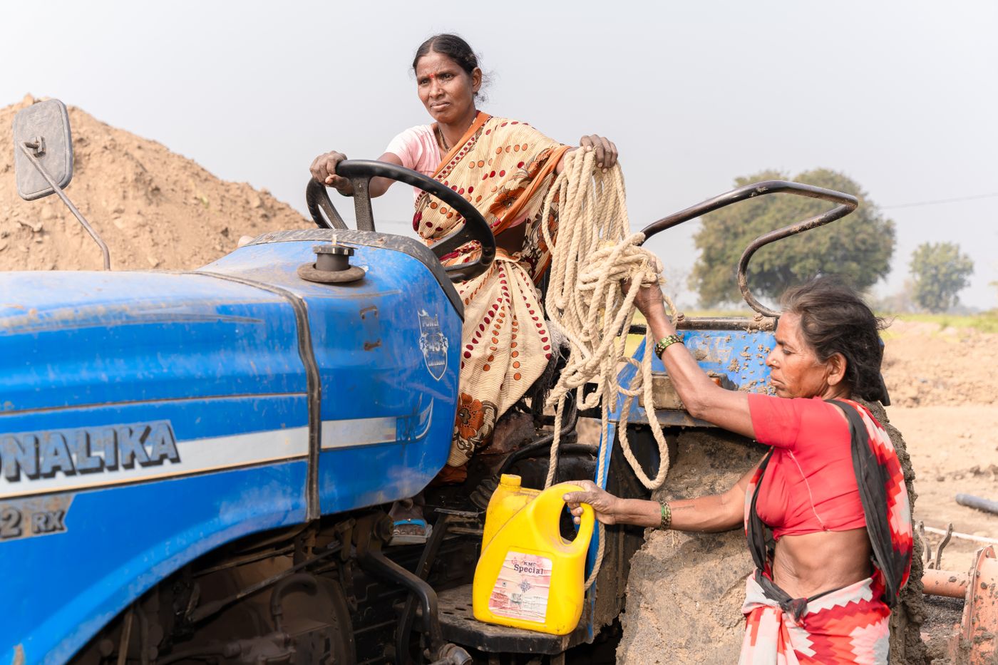 Women farmers working with a tractor