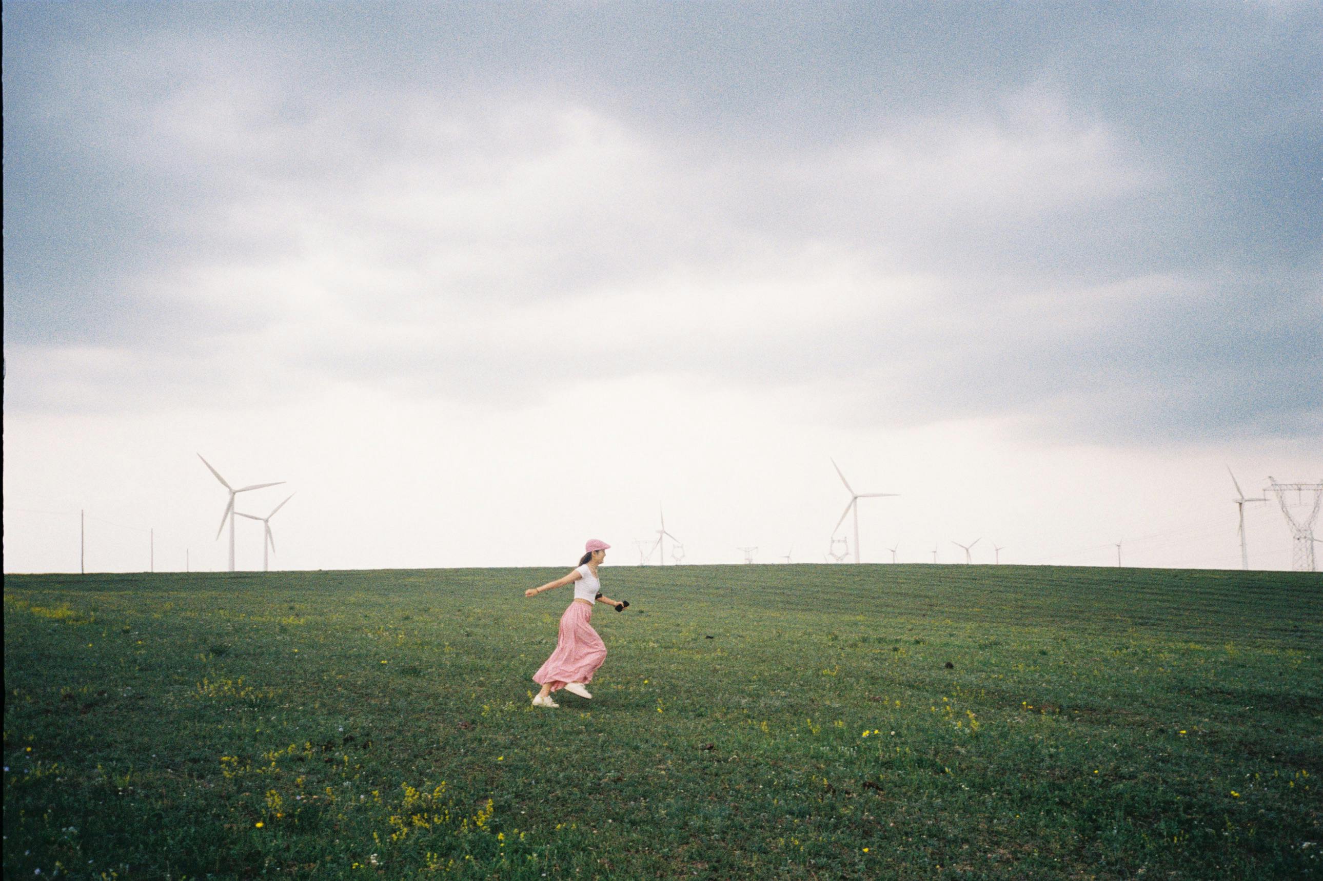 woman on a field among windmills