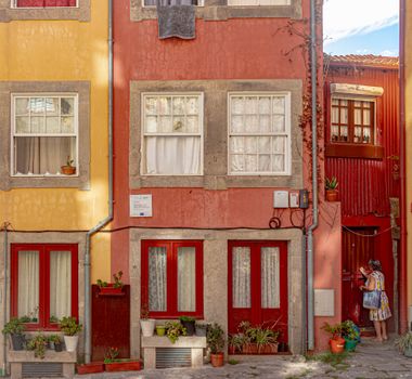 Charming colorful facades of residential buildings in Porto, Portugal with decorative plants.