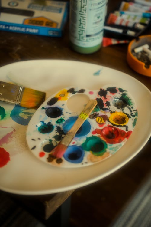 A plate with paint brushes and paint on it