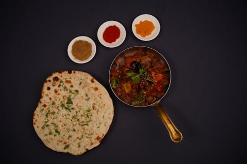 A plate of food with a flatbread and spices