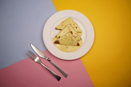 A plate of Shahi Tukda served on a vibrant background with cutlery.