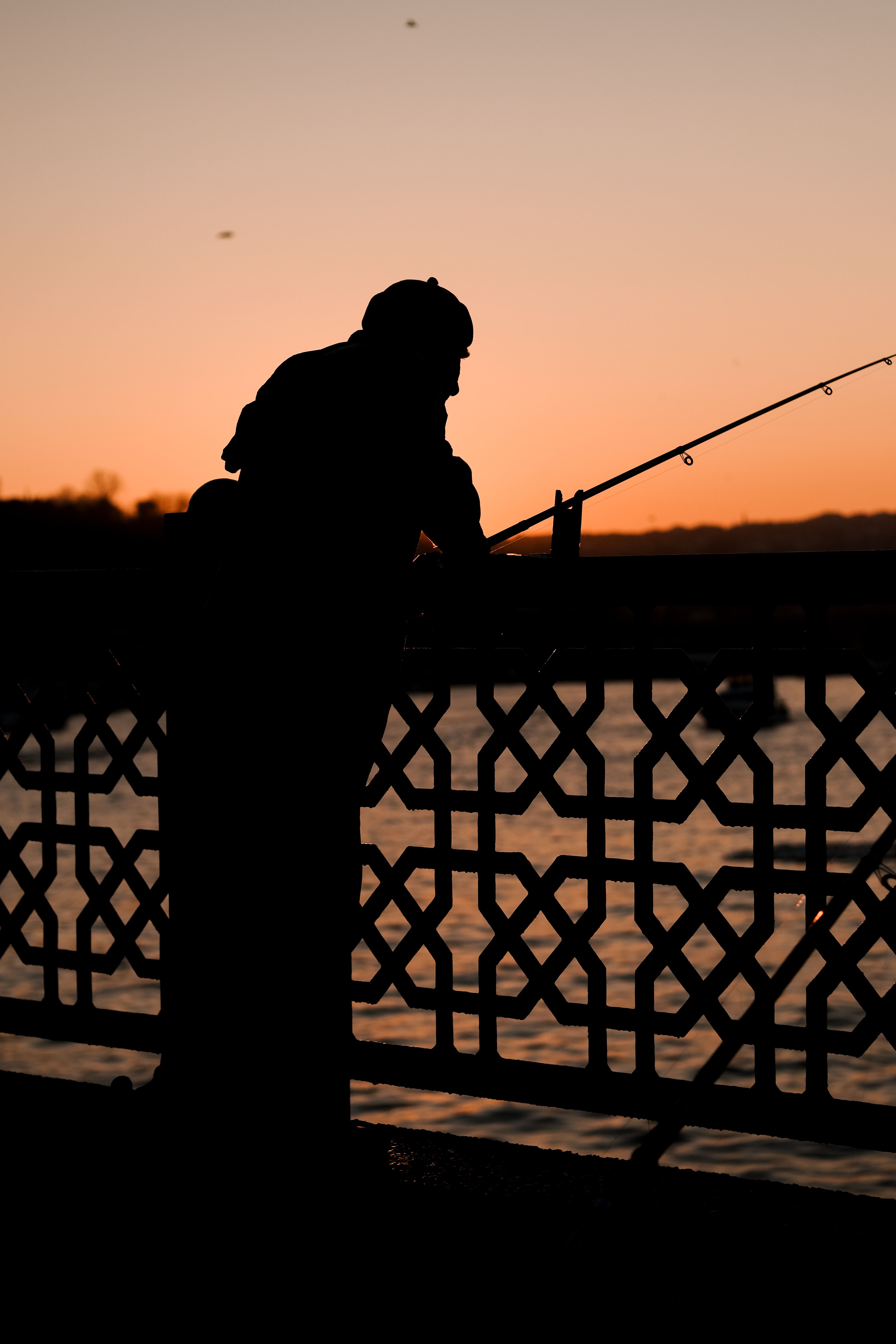 Silhouette of a Fisherman Standing on a Bridge by the Sunset · Free ...