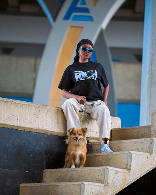 A woman sitting on the steps with her dog