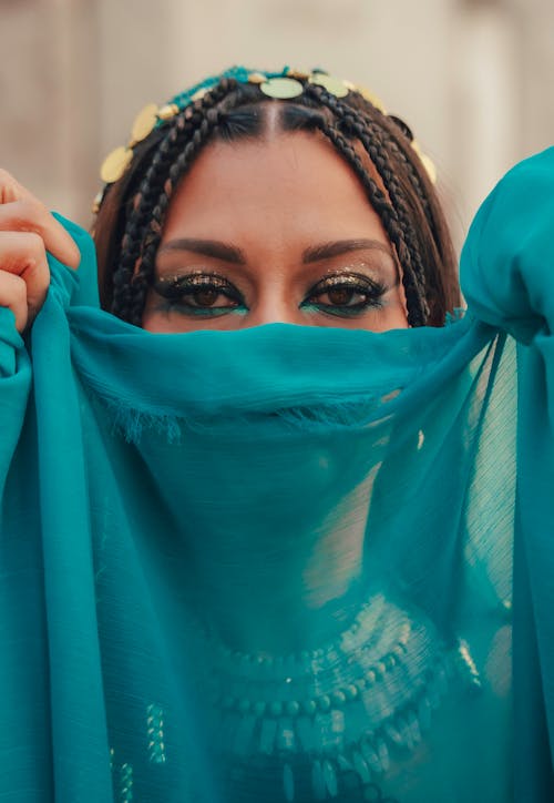 A woman wearing a blue veil covering her face