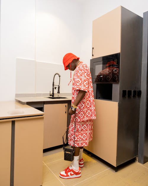 A man in red and white is standing in a kitchen