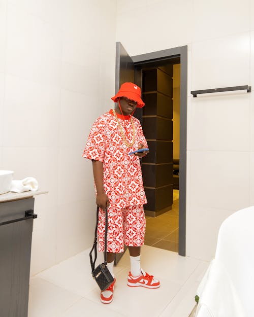 A man in a red and white outfit standing in a bathroom