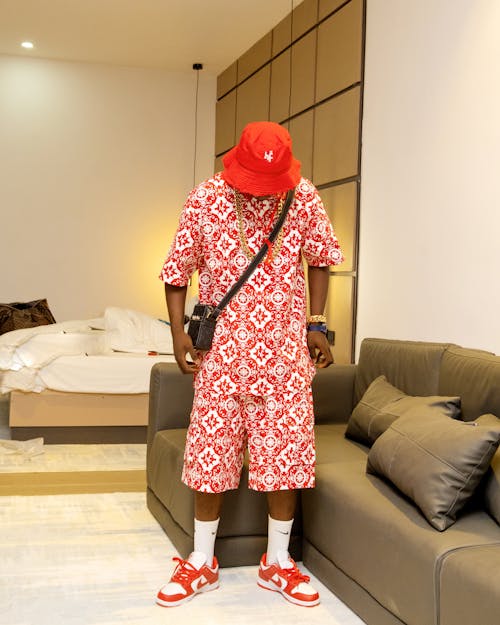 A man in red and white patterned clothing standing in a room