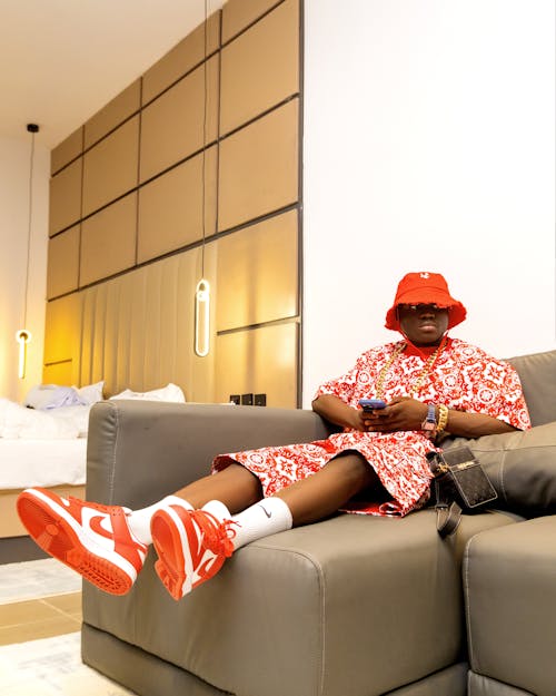 A man in red shoes sitting on a couch