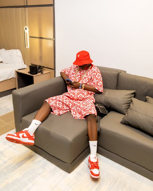 A man in red hat sitting on a couch