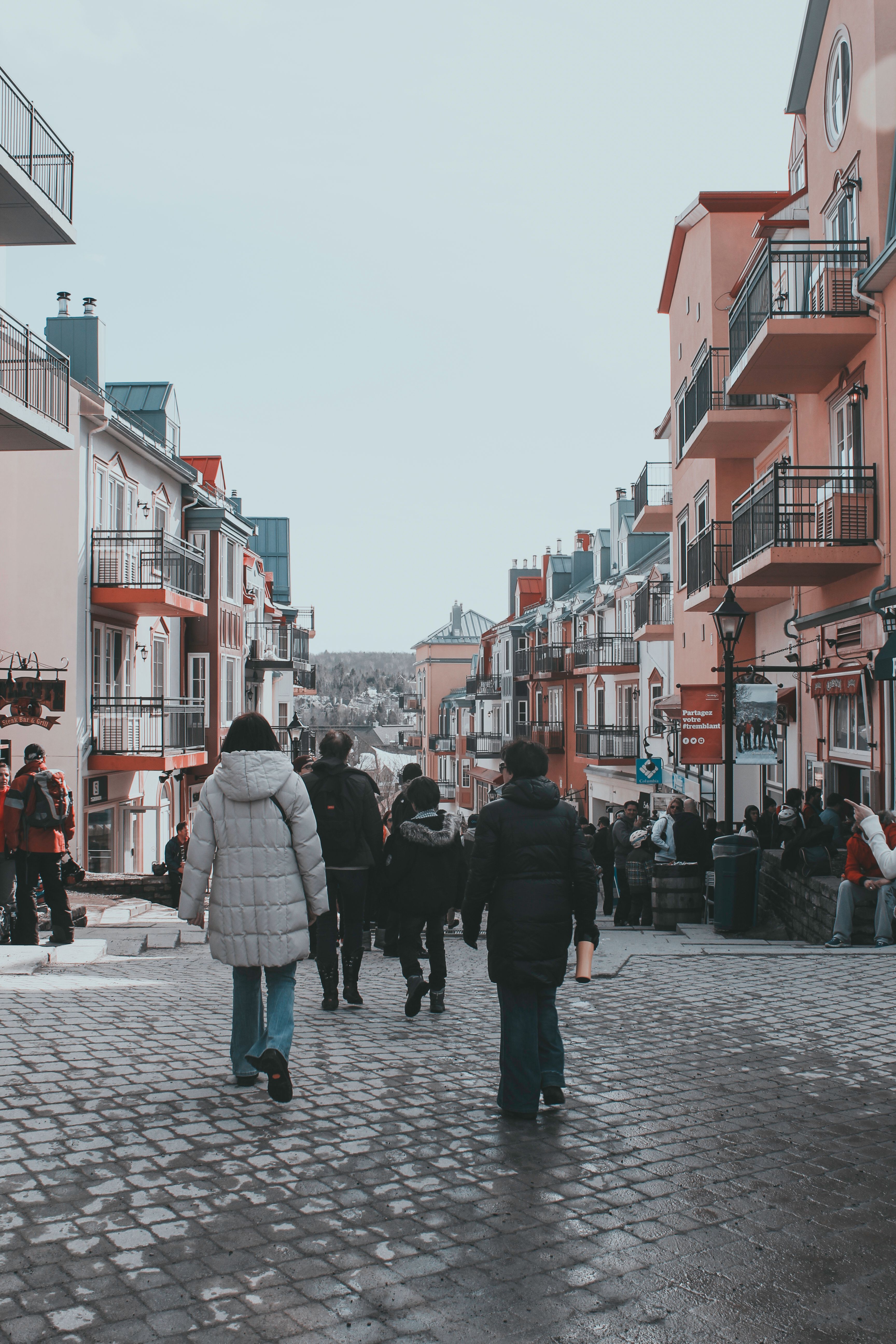 People walking down a cobblestone street in a city · Free Stock Photo