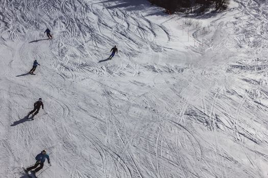 Aerial view of people skiing on snowy slopes in Mont-Tremblant, capturing winter sports amid scenic landscapes.