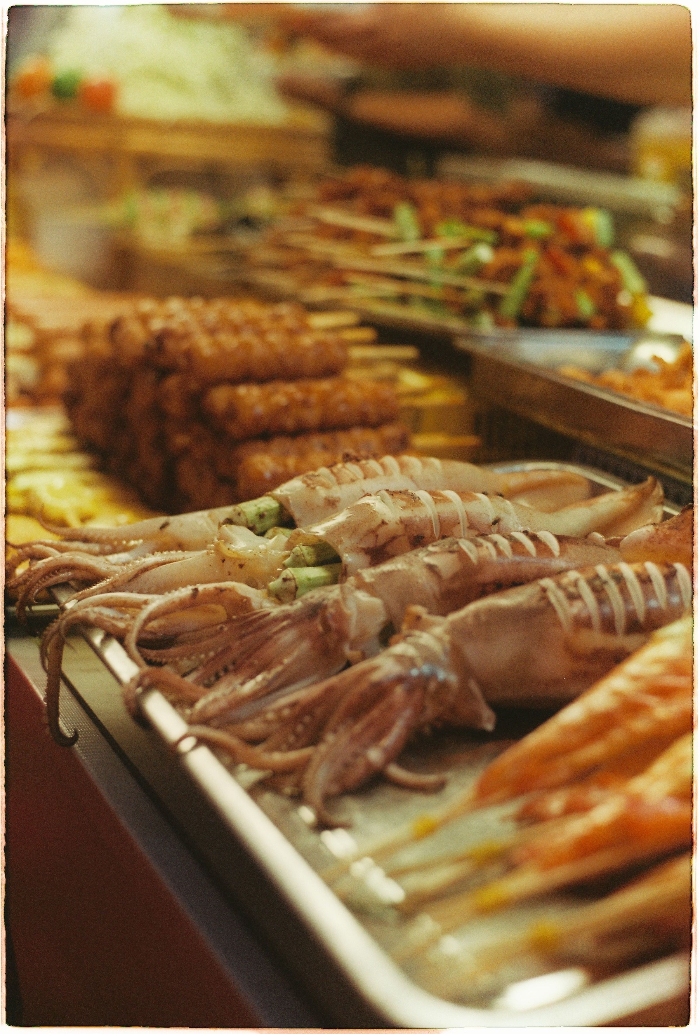 A vibrant display of fresh seafood including squid and shrimp at a bustling market.