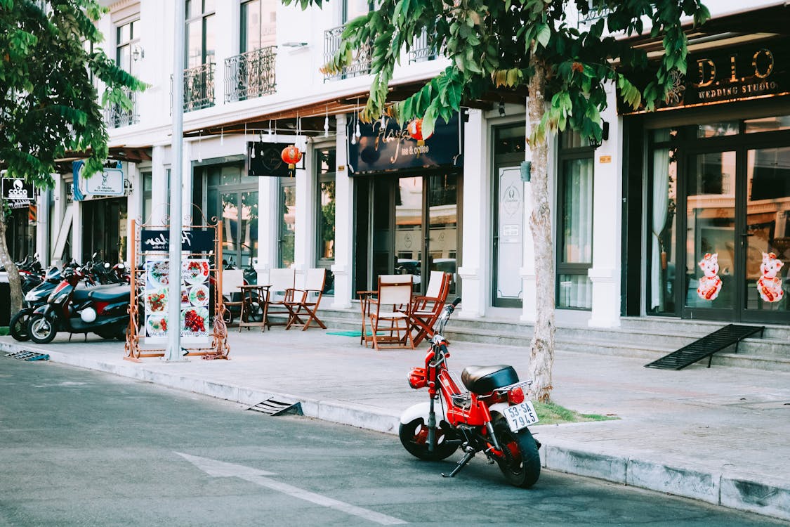 Free Red Motorcycle Parked Outside Storefront Stock Photo