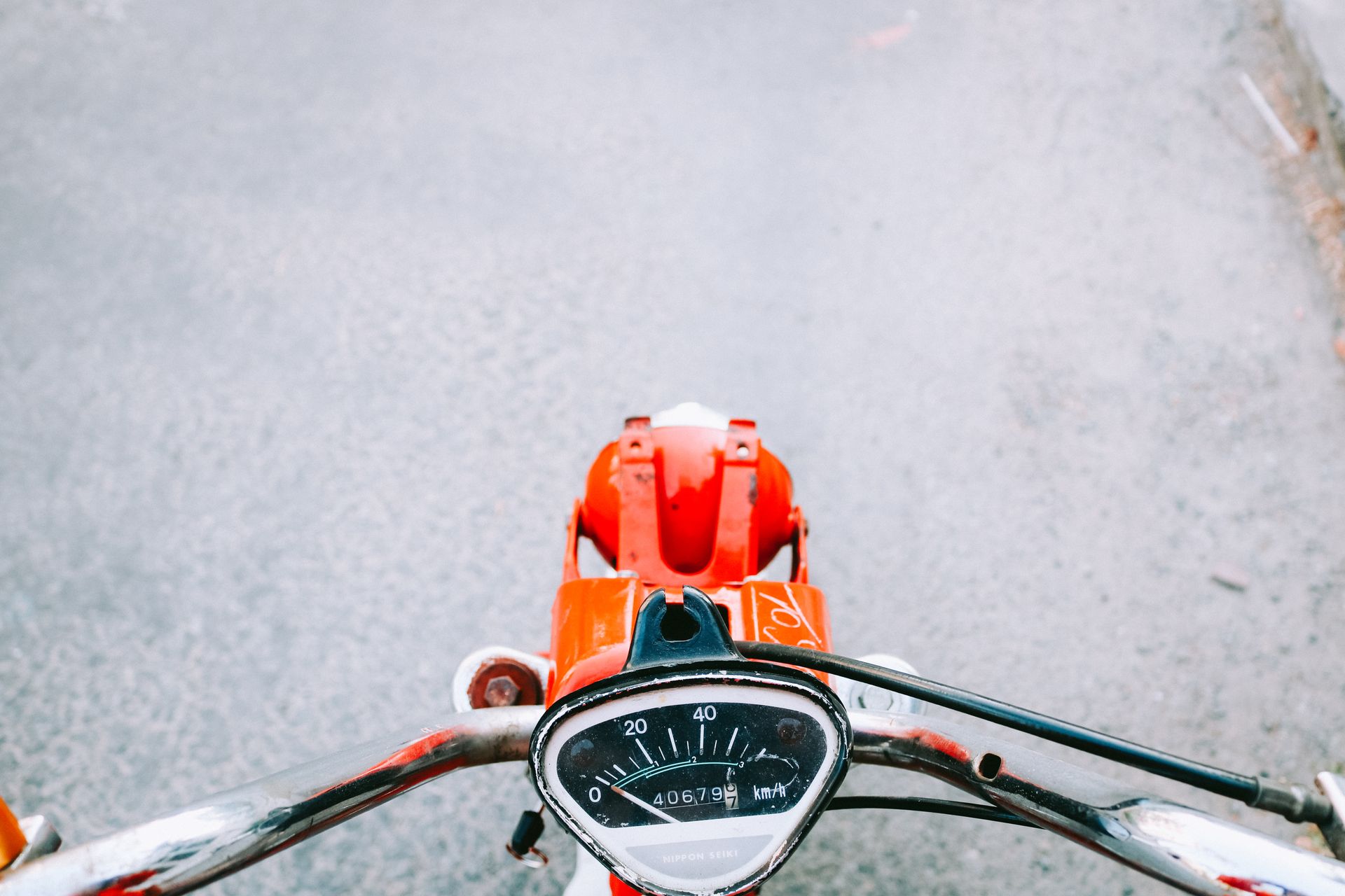 Speedometer view from a classic motorcycle on an empty road in Vietnam, focusing on travel and adventure.