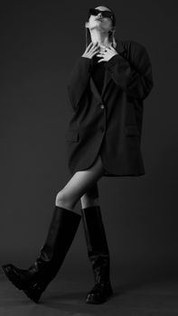 Elegant black and white portrait of a woman posing in chic fashion apparel.