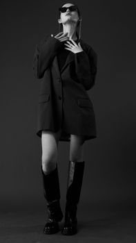 Stylish black and white portrait of a model posing in studio fashion shoot.