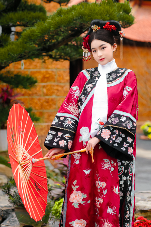 Free Portrait of an Asian woman in traditional clothing holding a red umbrella in Hà Nội, Vietnam. Stock Photo