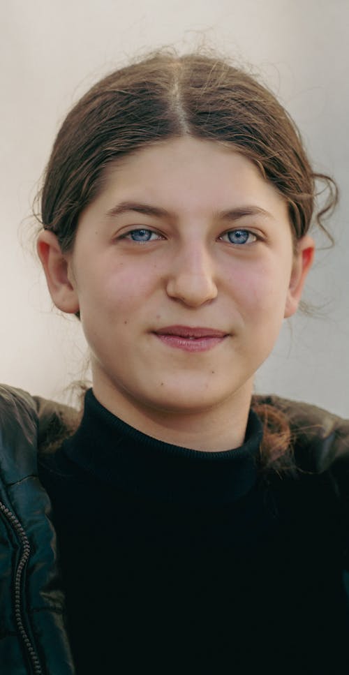 A young woman with blue eyes and a black jacket