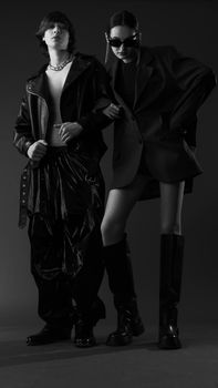 Elegant black and white fashion portrait of two models posing in stylish outfits.